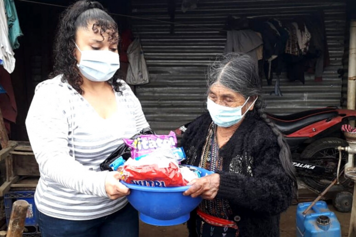 Adultos mayores reciben alimentos.