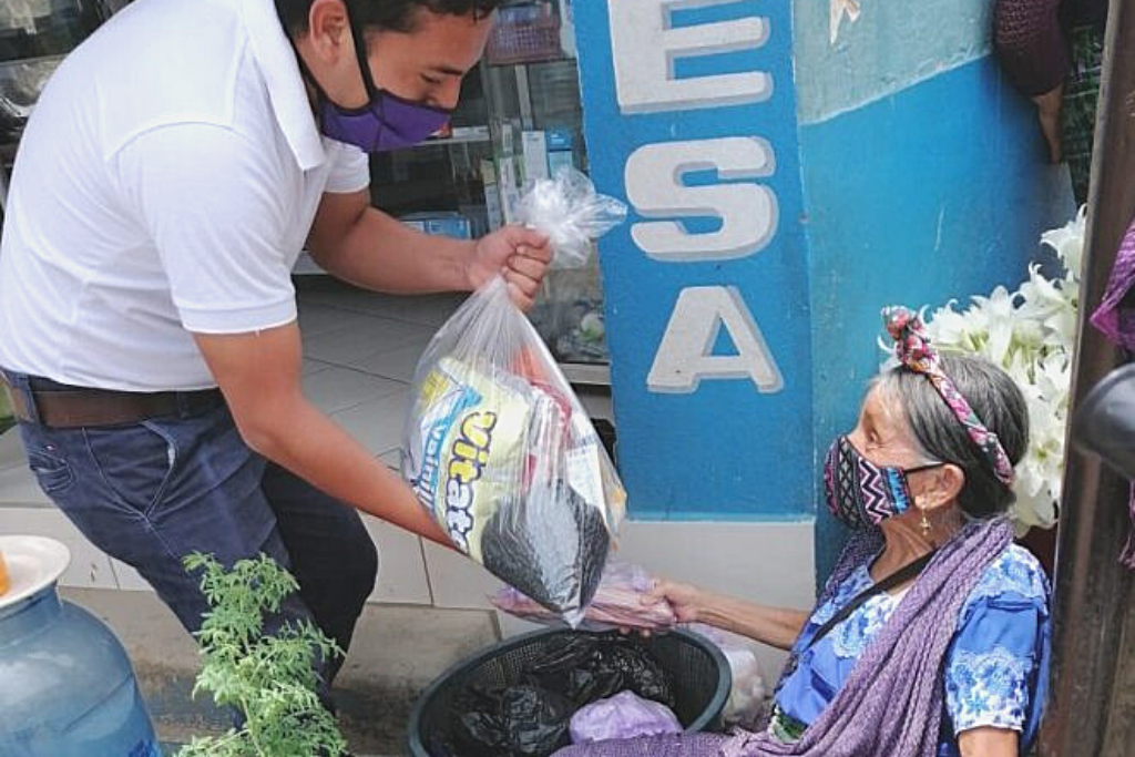 Adultos mayores reciben alimentos.