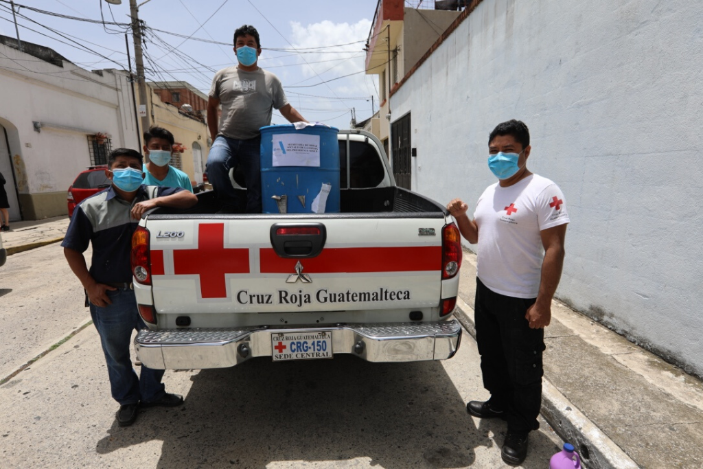 Miembros de la Crus Roja reciben el donativo de cloro.