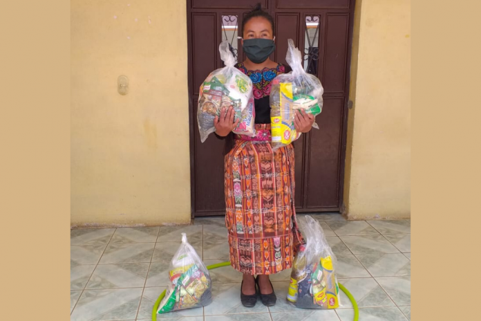 Una madre recibe alimentos no perecederos, el 21 de mayo pasado, distribuidos por SOSEP para niños beneficiarios del programa Hogares Comunitarios.